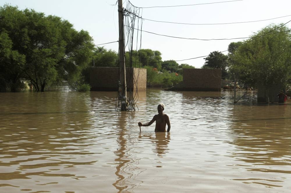 Resident Sarwae Hussain stands amid floodwaters as he waits for ration handouts following monsoon rains and rising water levels of the Chenab River, in Seetpur, Punjab province, Pakistan, REUTERS