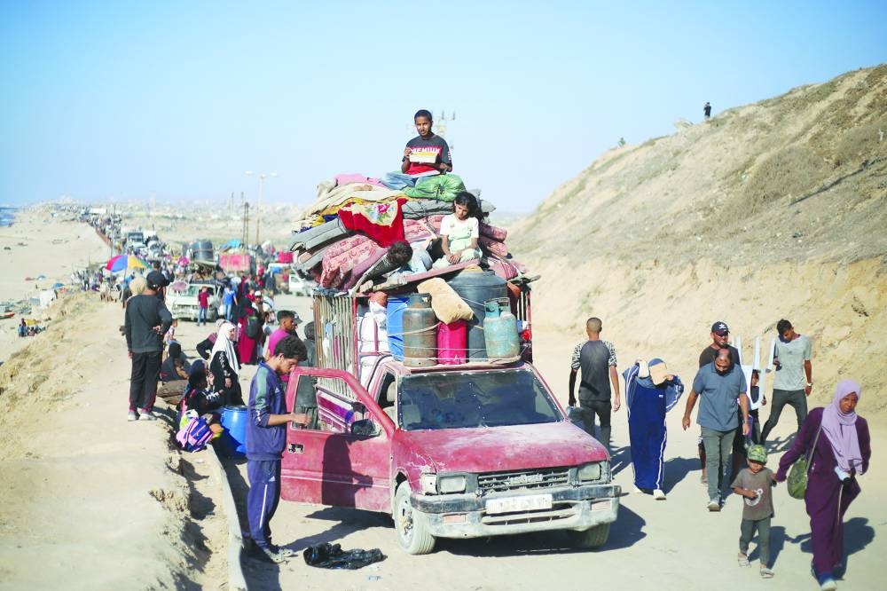 Displaced Palestinians move with their belongings southwards on a road in the Nuseirat refugee camp area in the central Gaza Strip following renewed Israeli evacuation orders for Gaza City, Tuesday