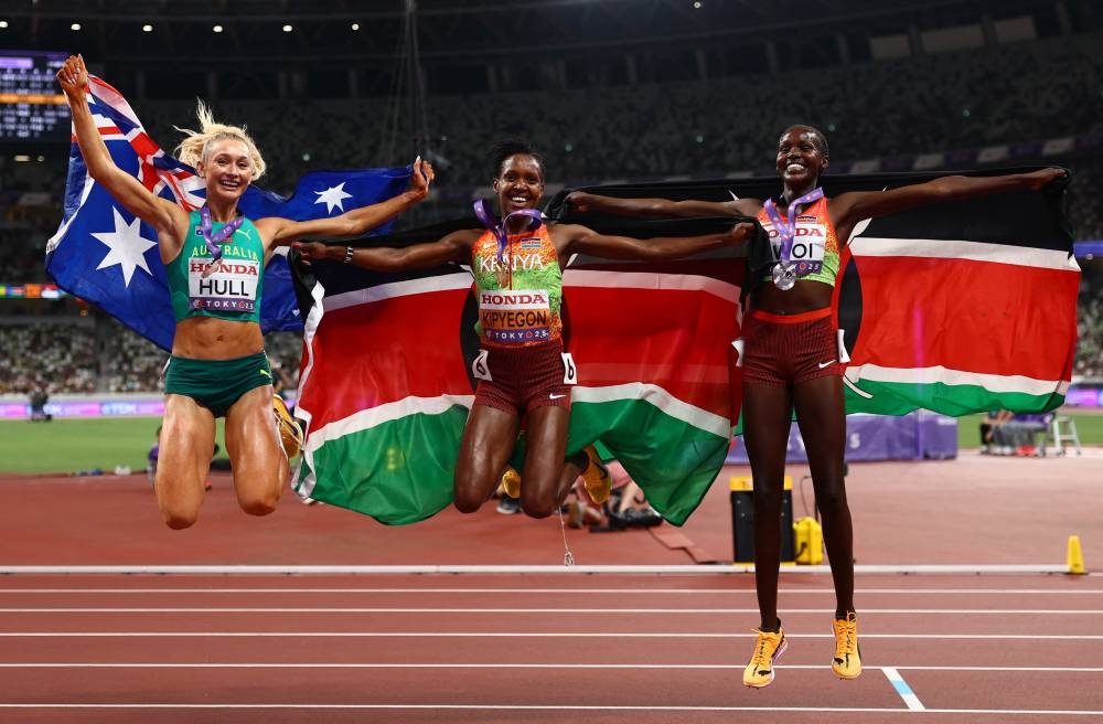 Kenya's Faith Kipyegon celebrates with her gold medal and a Kenya flag alongside silver medallist Kenya's Dorcus Ewoi and Bronze medallist Australia's Jessica Hull after winning the final. REUTERS