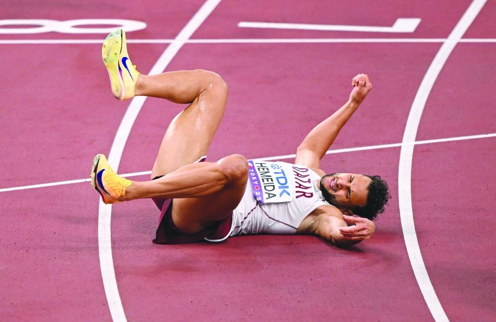 Qatar's Bassem Hemeida falls as he crosses the line during the heats. REUTERS