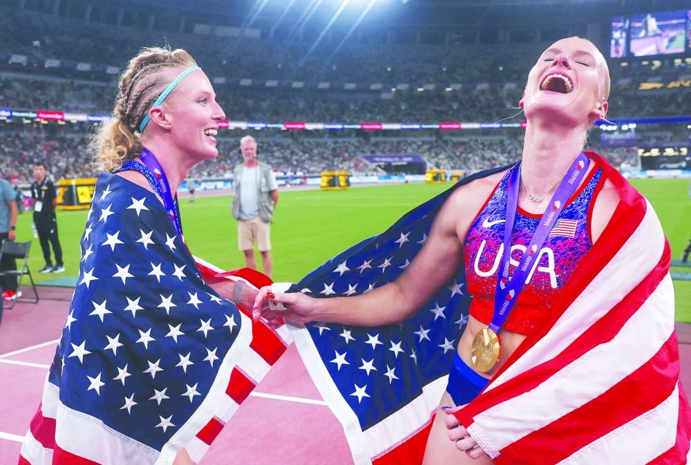 Gold medallist Katie Moon of the US celebrates with her national flag after winning the Women's Pole Vault Final alongside silver medallist Sandi Morris of the US. REUTERS