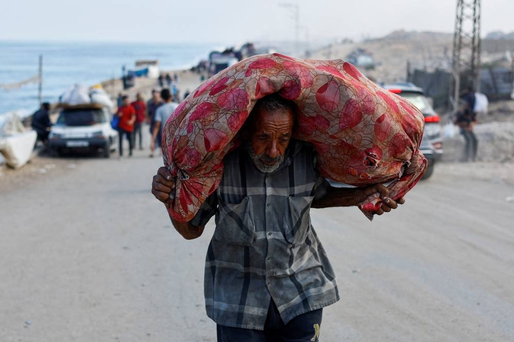 A displaced Palestinian man, fleeing northern Gaza moves southward in the central Gaza Strip Wednesday.
