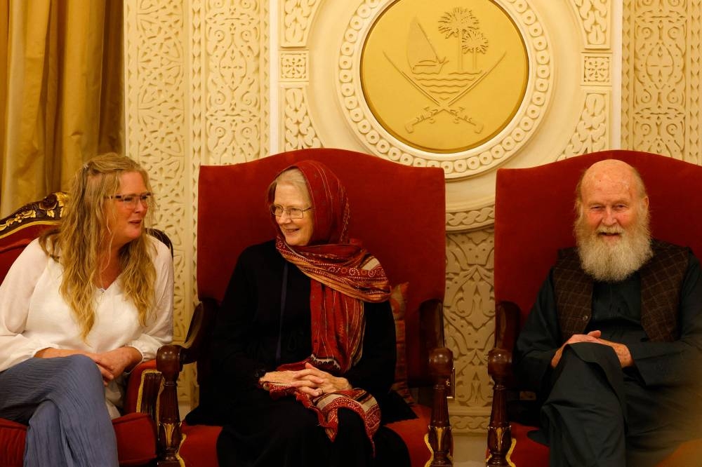 Sarah Entwistle (L) sits with her parents Barbie (C) and Peter Reynolds after landing at the airport in Doha on Friday. AFP
