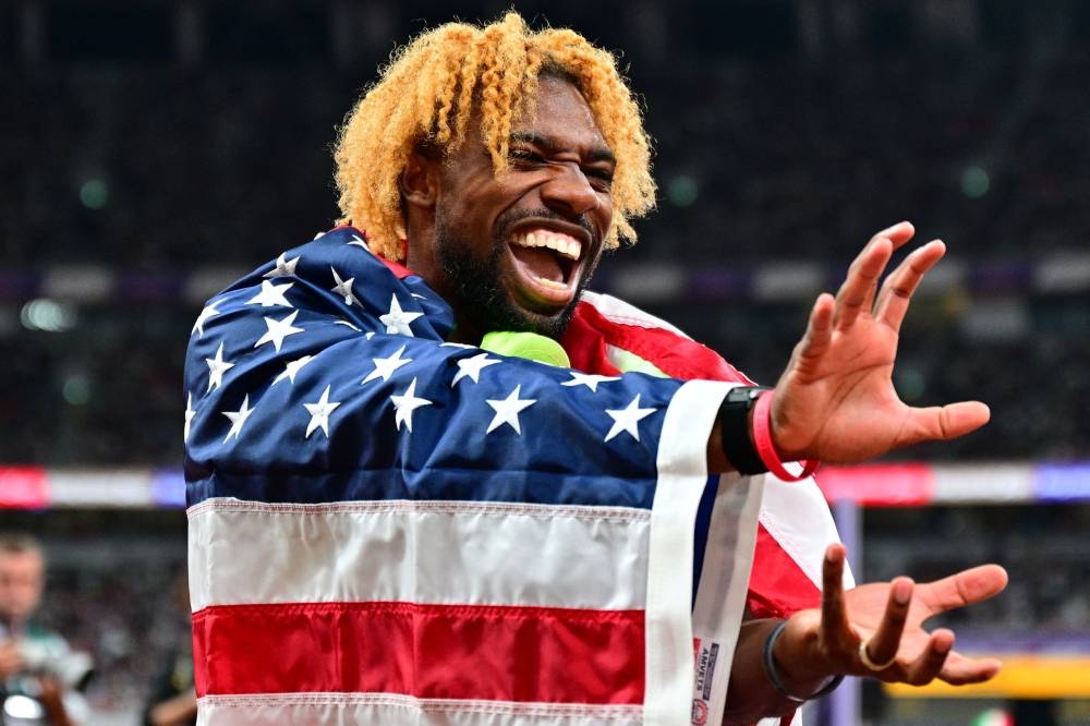 US' athlete Noah Lyles celebrates with his medal and country's flag after winning in the men's 200m final during the World Athletics Championships in Tokyo on Friday. AFP