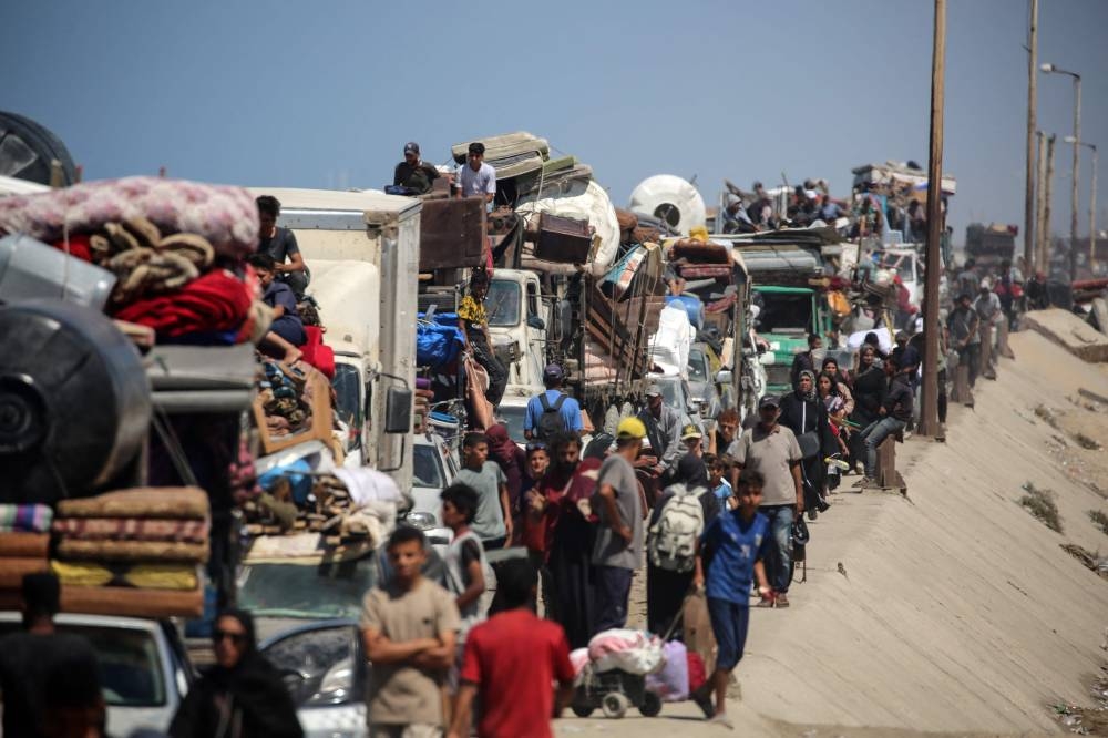 Palestinians from Gaza City move southwards with their belongings, on the coastal road near the Nuseirat refugee camp in the central Gaza Strip, Friday.