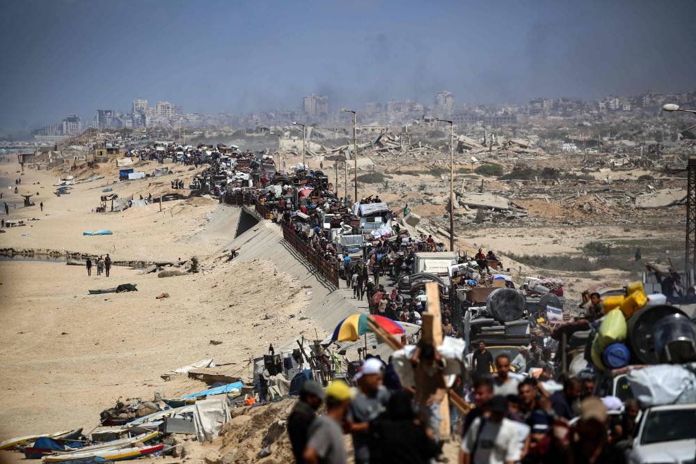 Palestinians from Gaza City move southwards with their belongings, on the coastal road near the Nuseirat refugee camp in the central Gaza Strip, Friday.