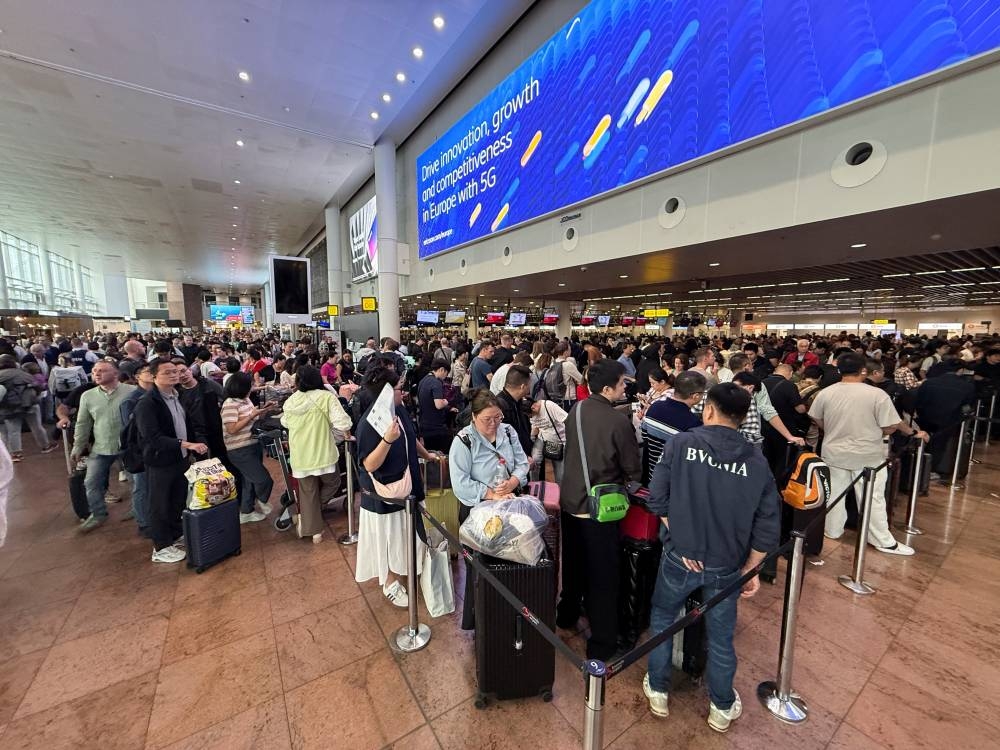 Travellers wait at Brussels airport, after a cyberattack at a service provider for check-in and boarding systems disrupted operations at several major European airports, in Zaventem near Brussels, Belgium September 20, 2025. REUTERS