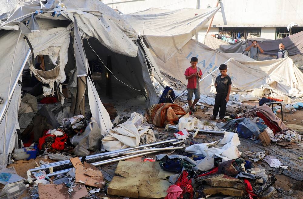 Palestinian children inspect the site of an Israeli strike on a tent sheltering displaced people, amid an Israeli military operation, in Gaza City, on Saturday. REUTERS