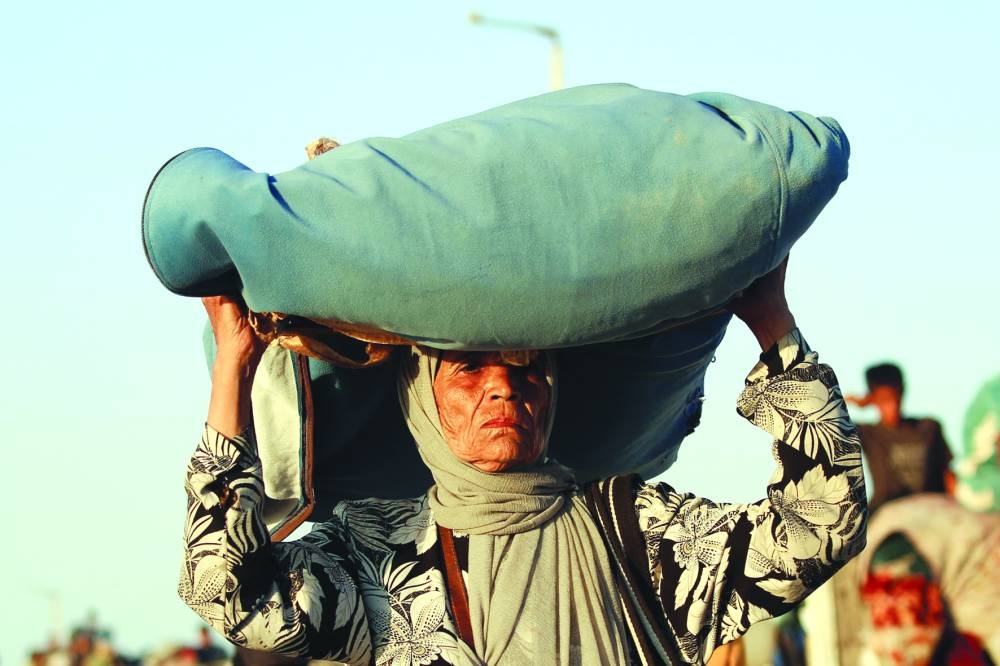 A displaced Palestinian moves with her belongings southwards on a road in the Nuseirat refugee camp area in the central Gaza Strip Saturday.