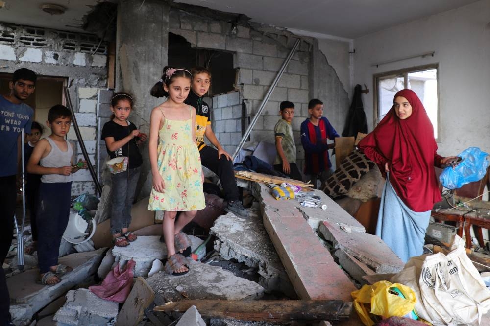 Palestinians kids gather as they inspect the damage inside a house belonging to Al-Hadad family after it was hit in an overnight Israeli strike, amid an Israeli military operation, in Gaza City on Sunday. REUTERS