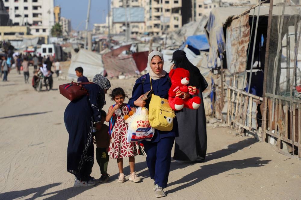 Displaced Palestinians flee amid an Israeli military operation, after Israeli forces ordered residents of Gaza City to evacuate to the south, in Gaza City, on Sunday. REUTERS