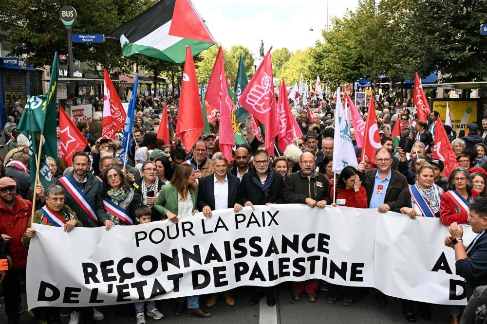 National secretary of French left-wing The Ecologistes party Marine Tondelier (C-L), National secretary of French far-left Communist party (PCF) Fabien Roussel (C) and First secretary of French left-wing Socialist party (PS) Olivier Faure (C-R) hold a banner reading "For peace" as they lead a march asking for the "recognition of the State of Palestine and the end of the genocide", in Paris on Sunday. AFP