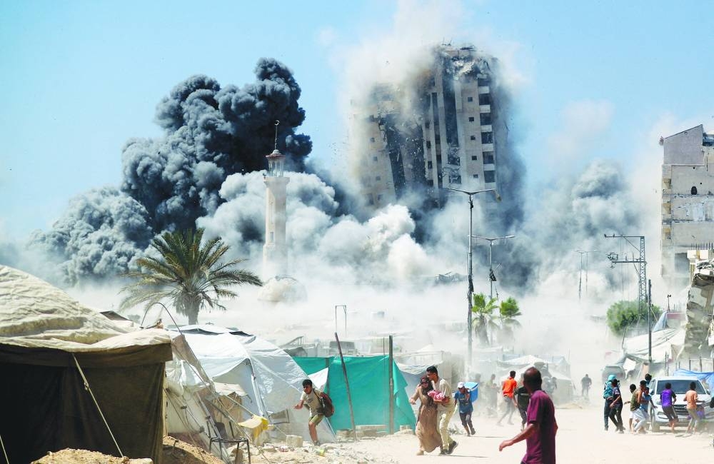 Recent photo shows Palestinians running as the 15-storey Mushtaha Tower collapses after being hit by an Israeli air strike, in Gaza City.