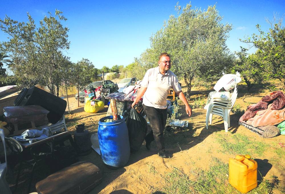 Palestinian Shady Salama Al-Rayyes, who fled his apartment in the 15-story Mushtaha Tower in Gaza City minutes before an Israeli strike hit the building, carries his belongings in Deir Al-Balah in the central Gaza Strip, September 18, 2025. REUTERS/Dawoud Abu Alkas