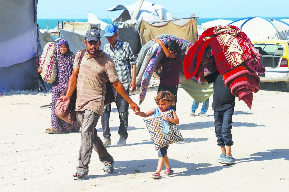 Displaced Palestinians flee amid an Israeli military operation, after Israeli forces ordered residents of Gaza City to evacuate to the south, in Gaza City, yesterday.