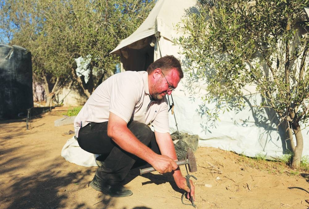 Palestinian Shady Salama al-Rayyes, who fled his apartment in the 15-storey Mushtaha Tower in Gaza City minutes before an Israeli strike hit the building, sets up a tent in Deir Al-Balah in the central Gaza Strip.