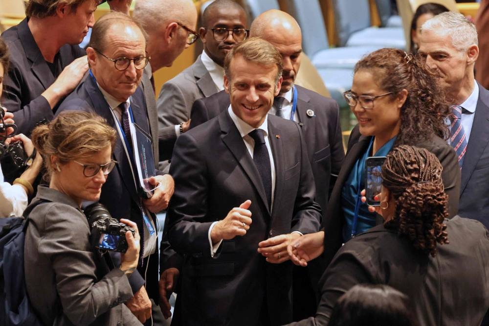 French President Emmanuel Macron (C) greets delegates as he arrives for a United Nations Summit on Palestinians at UN headquarters during the United Nations General Assembly (UNGA) in New York on Monday. AFP