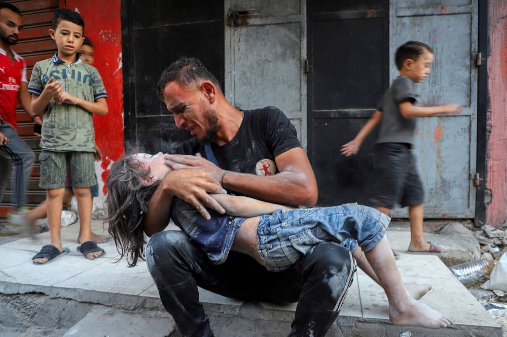 Palestinian father Dawoud Sukar mourns as he holds the body of his son Saker, 3, who was killed in Israeli strikes on houses at Shati (Beach) refugee camp, amid an Israeli military operation, in Gaza City September 23, 2025. REUTERS