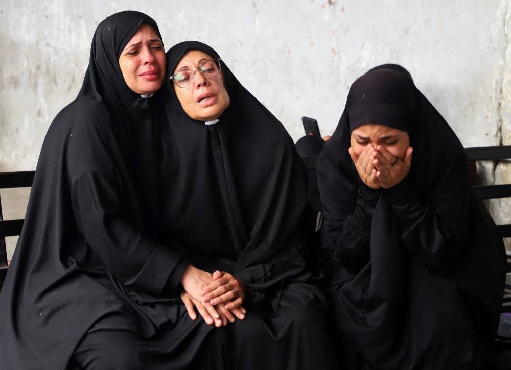 Mourners react during the funeral of Palestinians, who were killed in a deadly overnight Israeli strike on a building where displaced people were taking shelter, amid an Israeli military operation, at Al-Ahli Arab Hospital in Gaza City, on Wednesday. REUTERS