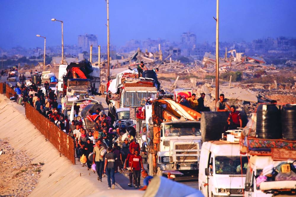 Displaced Palestinians move with their belongings southwards on a road in the Nuseirat refugee camp area yesterday.