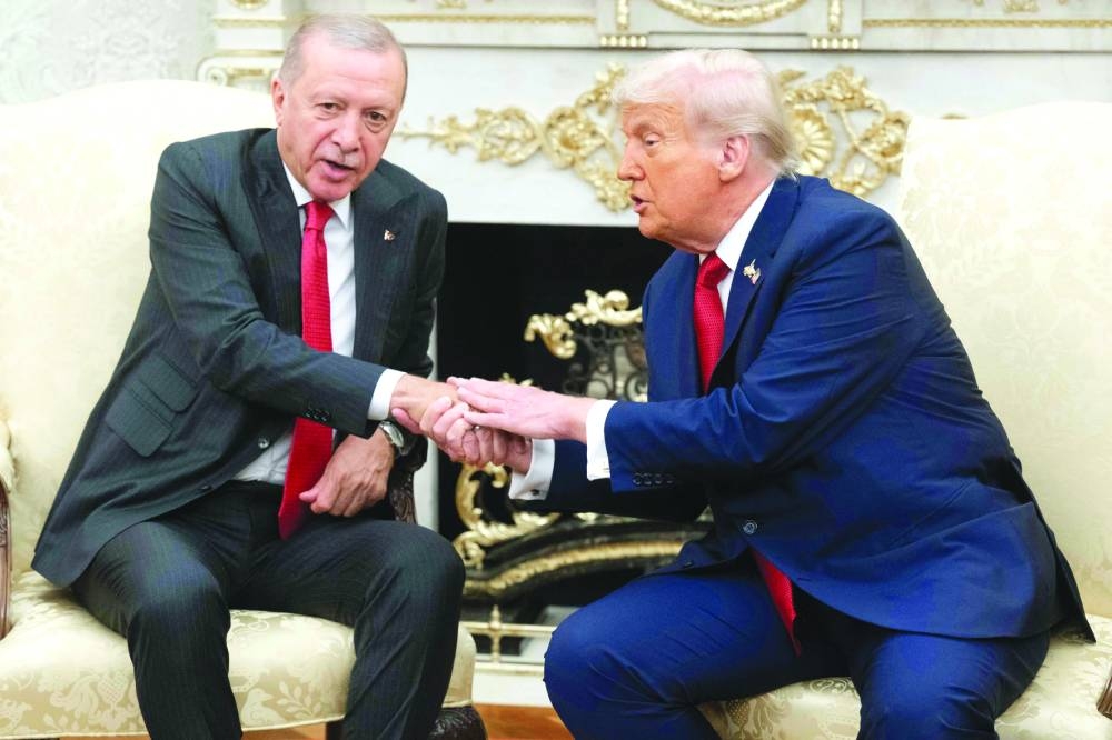 Trump shakes hands with Erdogan as they meet in the Oval Office of the White House yesterday