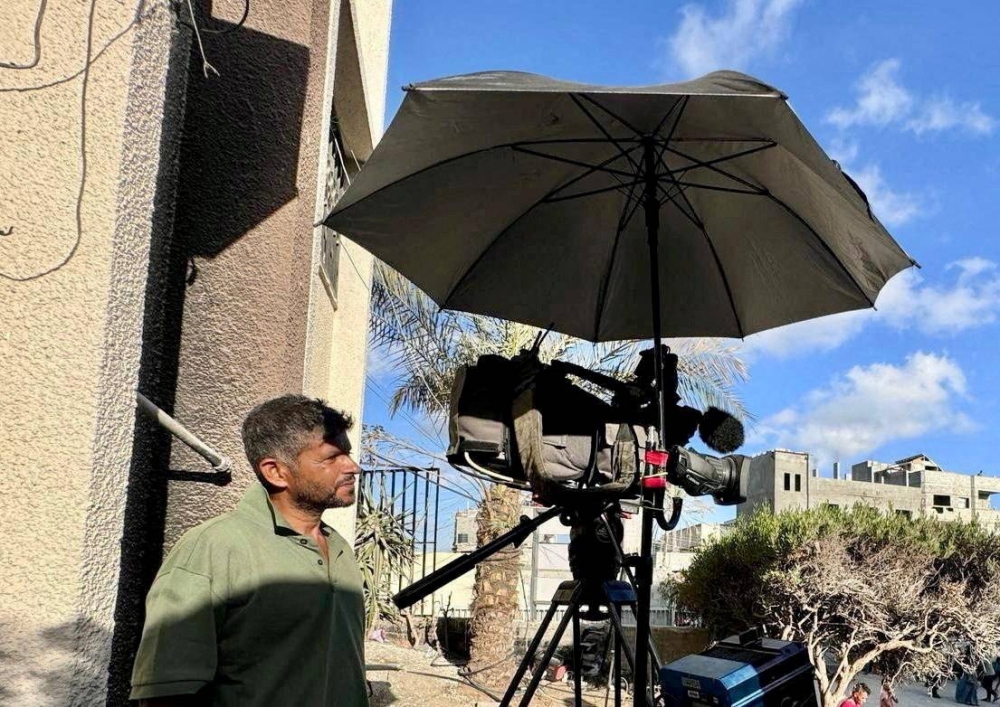 Reuters cameraman Hussam al-Masri, who was killed in Israeli strikes on Nasser hospital on August 25, 2025, stands next to his camera as he works at Nasser hospital, in Khan Younis in the southern Gaza Strip in this undated picture. REUTERS