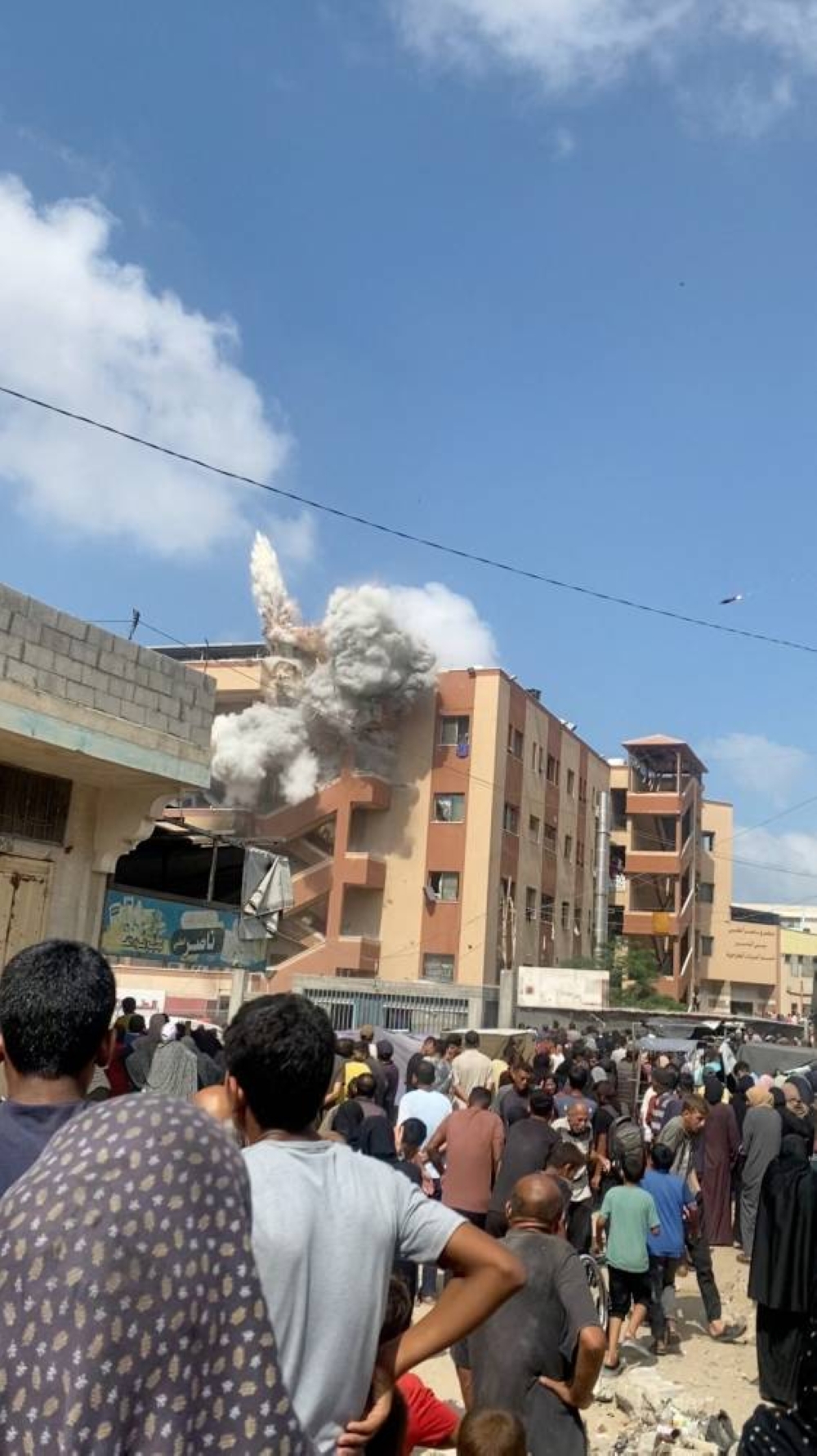 An Israeli military munition is seen in the sky as smoke rises from the impact of an Israeli strike on Nasser Hospital's eastern staircase on August 25, 2025, in Khan Younis, in Gaza, in this still frame from video. REUTERS