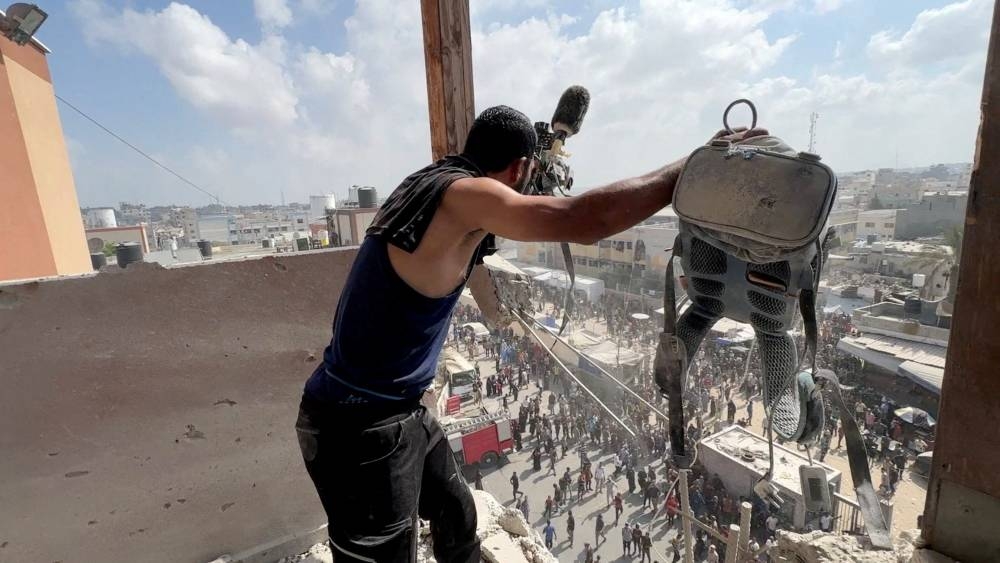 A man reacts as he holds the equipment used by Reuters cameraman Hussam al-Masri at the site where he was killed along with other journalists and people in Israeli strikes on Nasser hospital, in Khan Younis in the southern Gaza Strip, in this still image taken from a video shot by Reuters photographer Hatem Khaled, who was wounded shortly afterwards in another strike while he was filming the site, August 25, 2025. REUTERS