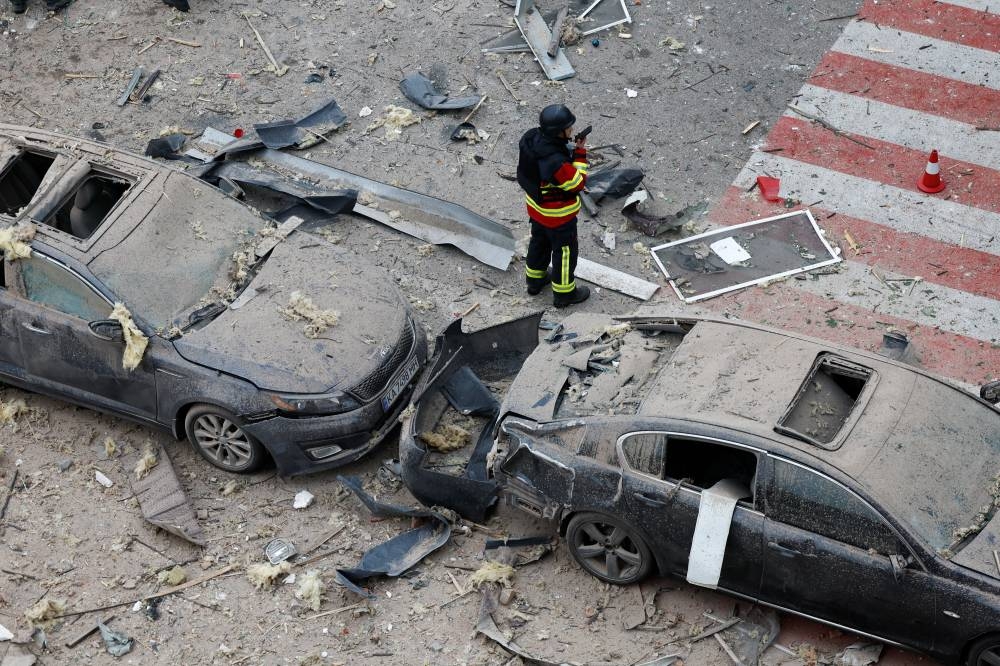An emergency worker talks on phone at an impact site in a residential neighbourhood after Russian drone and missile attacks in Kyiv, Ukraine, September 28, 2025. REUTERS
