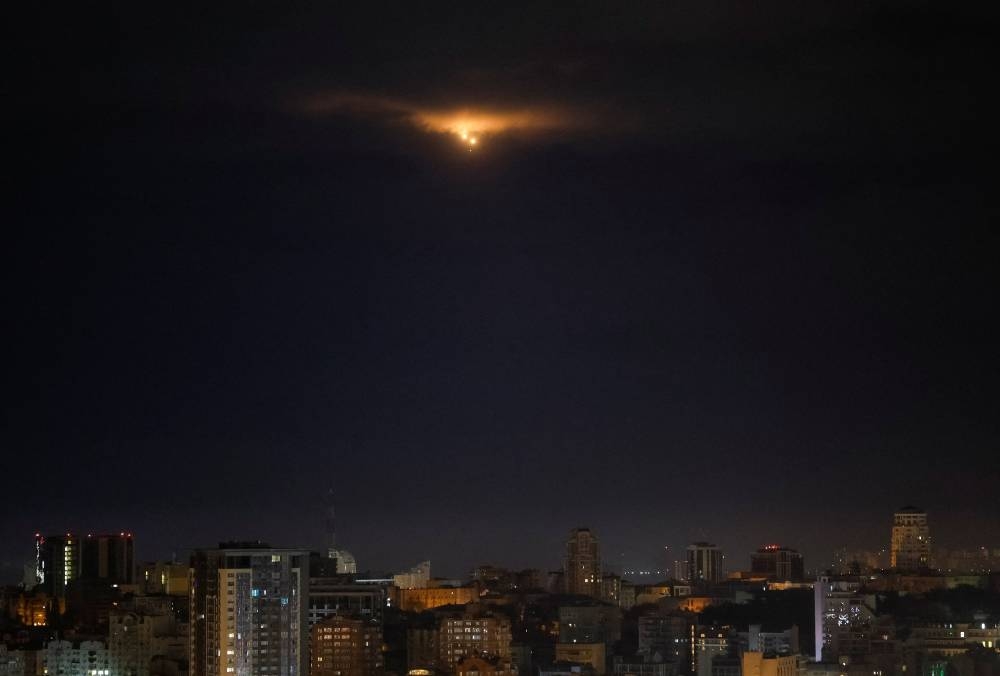 Explosions are seen in the night sky as Ukrainian servicemen fire towards drones during a Russian missile and drone strike, amid Russia's attack on Ukraine, in Kyiv, Ukraine September 28, 2025. REUTERS
