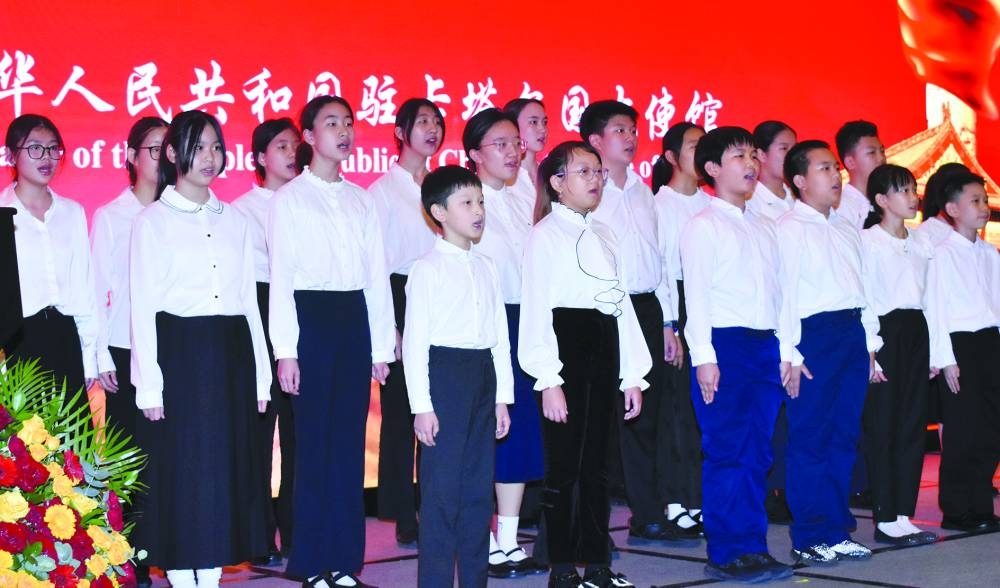 Chinese children singing the Qatari and Chinese anthems.