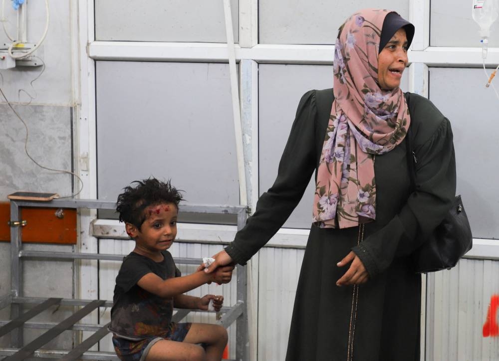 A woman reacts next to a child as wounded Palestinians receive treatment at Al-Shifa Hospital after being injured in an Israeli strike, amid an Israeli military operation, according to medics, in Gaza City, on Monday. REUTERS