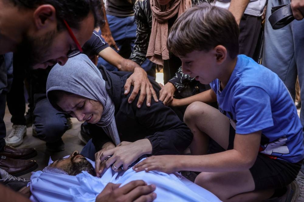 The family of a Palestinian man killed in an Israeli strike mourn over his body outside al-Aqsa Martyrs hospital in Deir el-Balah in the central Gaza Strip, on October 1, 2025. The Israeli military said it will close on October 1 the last remaining route for residents of southern Gaza to access the north, as it presses its offensive on Gaza City. (AFP)