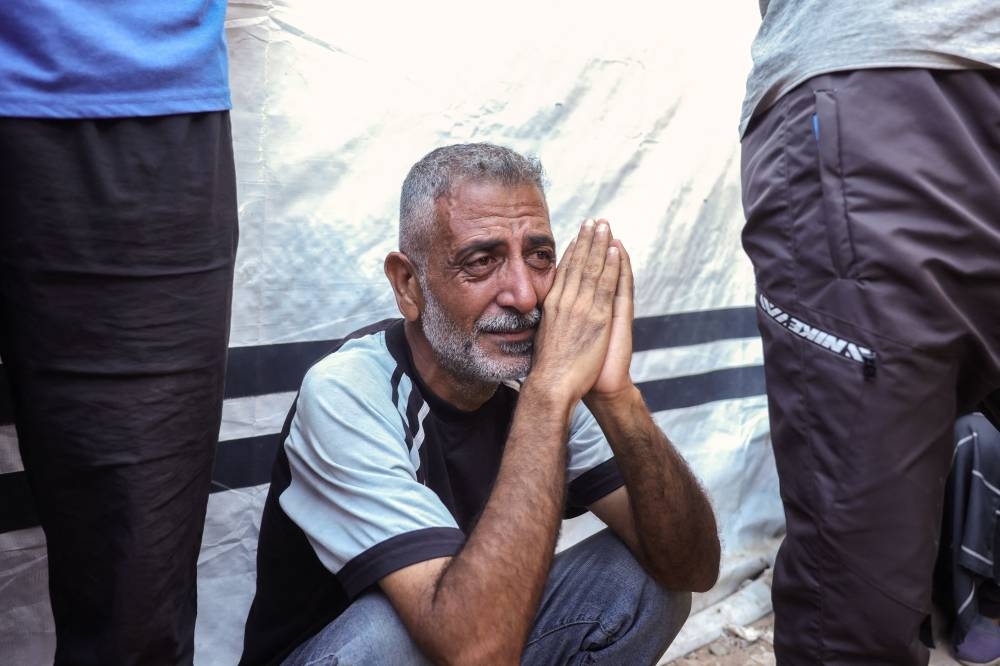 A Palestinian man mourns the death of a loved one killed in an Israeli strike, before a funeral procession outside al-Aqsa Martyrs hospital in Deir el-Balah in the central Gaza Strip, on Wednesday. AFP