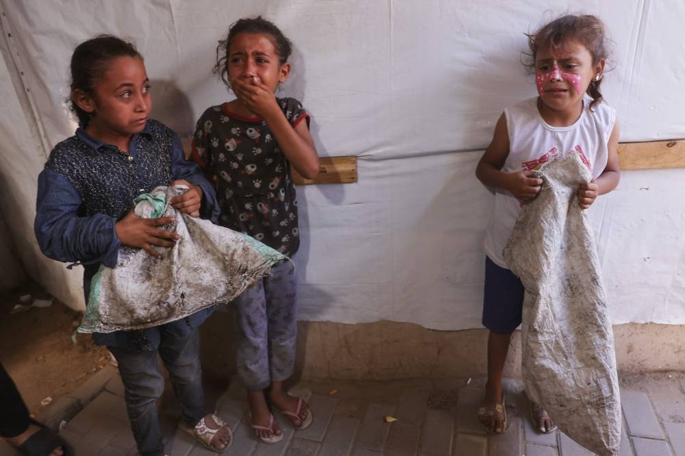 Palestinian girls cry after an Israeli strike hit a tent used by  displaced Gazans inside the grounds of the Shuhada al-Aqsa (Aqsa Martyrs) Hospital in Deir al-Balah in the central Gaza Strip on Wednesday. AFP