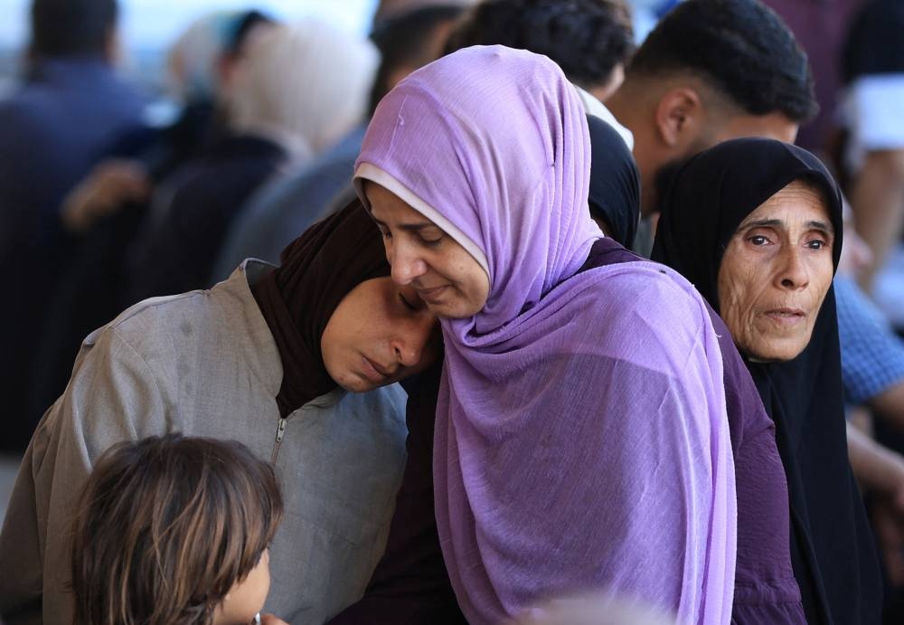 Mourners react during the funeral of Palestinians, who, according to medics, were killed in Israeli strikes, at Al-Aqsa Martyrs hospital, in Deir Al-Balah in the central Gaza Strip, on Wednesday. REUTERS