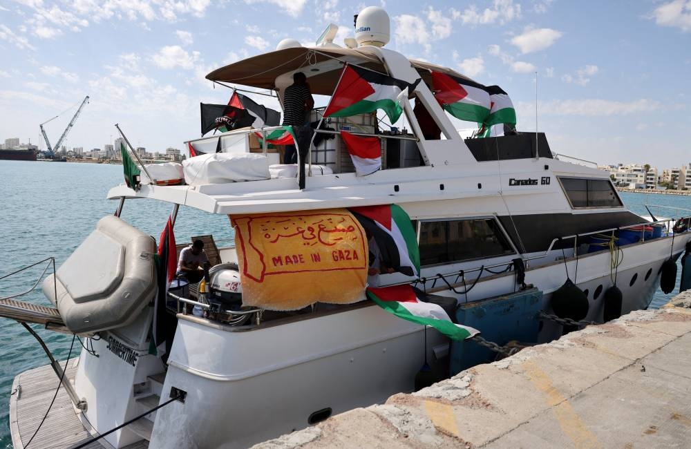 People gather on a boat from a flotilla that had been carrying aid to Gaza until it was intercepted by Israel, docked in the port of Larnaca, on Friday. REUTERS