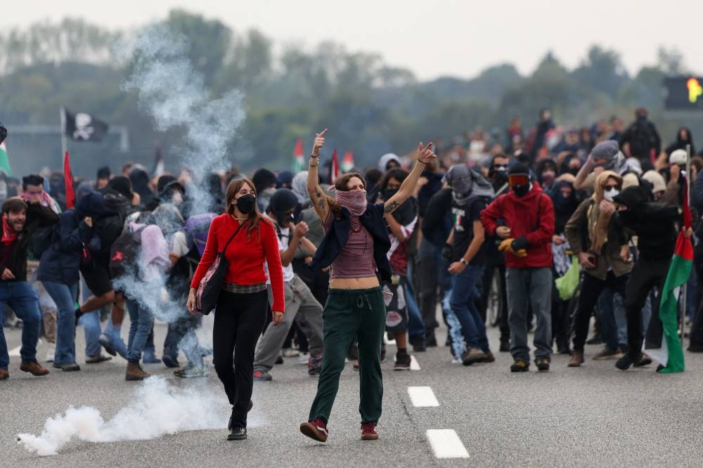 Pro-Palestinian protesters react as they clash with riot police at Milan's ring road on Friday. REUTERS