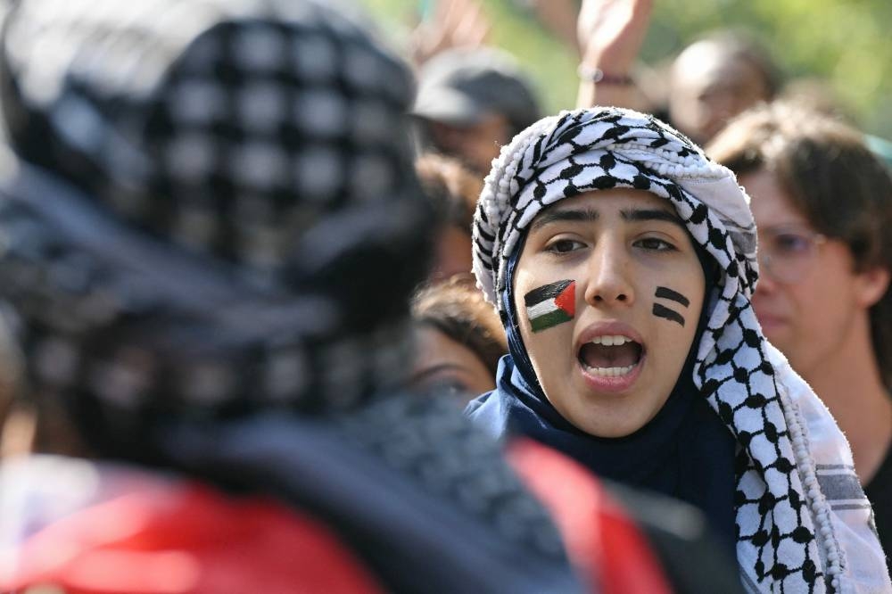 A Pro-Palestinian demonstrator shouts slogans to support the Palestinians and to protest against the interception of the Global Sumud Flotilla, in Milan, on Friday. AFP