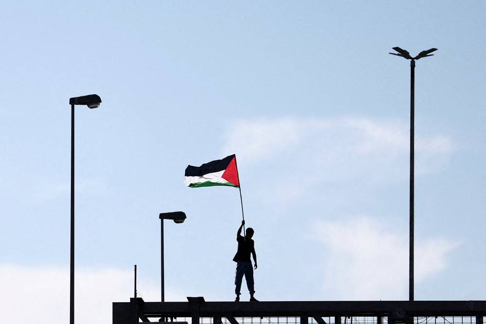 A pro-Palestinian demonstrator waves a Palestinian flag while protesting during a nationwide strike, on Friday. REUTERS