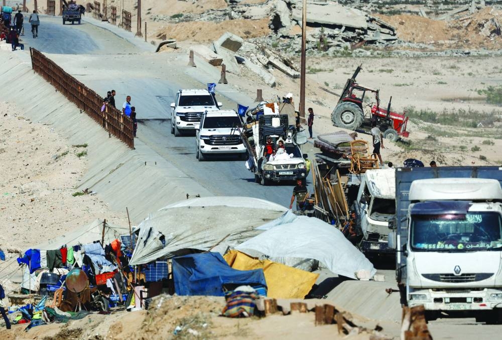 United Nations vehicles drive on a road as displaced Palestinians, fleeing northern Gaza due to an Israeli military operation, move southwards following Israeli forces' orders to leave Gaza City, in the central Gaza Strip Friday.
