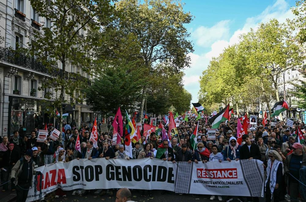 Demonstrators hold a banner reading "Gaza, stop genocide, restistance antisionist, anticolonialist, urgence palestine" during a rally in solidarity with Palestinians and to protest against the interception by the Israeli army of the Global Sumud Flotilla, in Paris on Saturday. AFP