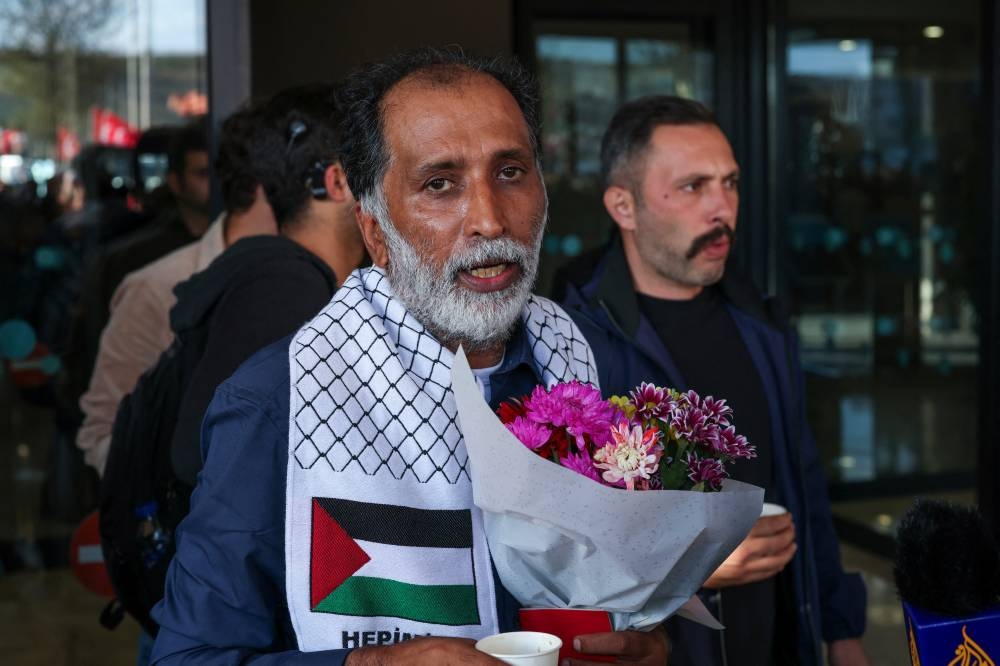 Sami Abulaziz Hasan Ebrahim of Bahrain, one of the activists who were sailing aboard vessels from the Global Sumud Flotilla which were seized by Israeli forces, holds flowers after arriving at Istanbul Airport on a special flight, in Istanbul, on Saturday. REUTERS