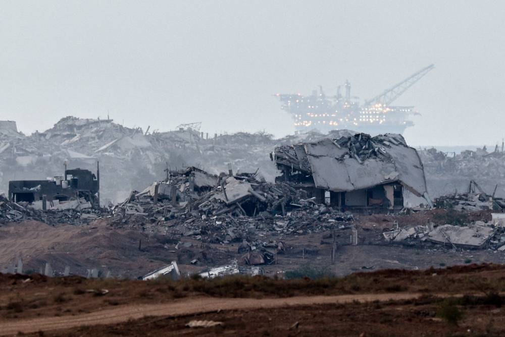 Destroyed buildings in Gaza, with an oil rig in the distance, as seen from Israel, on Saturday. REUTERS