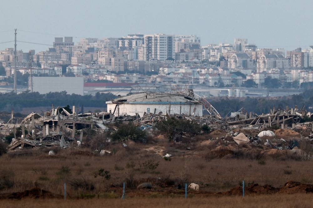 Destroyed buildings in Gaza, with the Israeli city of Ashkelon in the distance, as seen from Israel, on Saturday. REUTERS