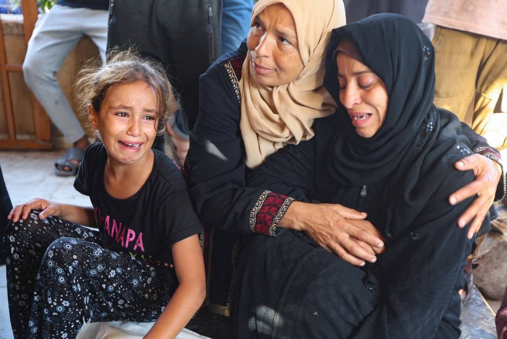 Mourners react at the funeral of Palestinians killed in an Israeli strike on Saturday, according to medics, at Nasser Hospital in Khan Younis, southern Gaza Strip, yesterday.
