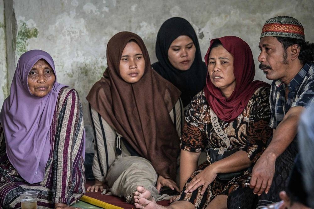 Relatives of missing students gather as rescuers continue searching for victims at the Al Khoziny Islamic boarding school in Sidoarjo, East Java, on Sunday. AFP