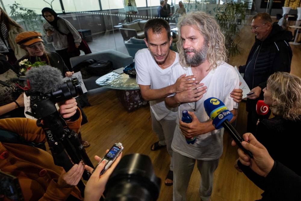 Activists Peter Svestka (L) from Slovakia and Sander Theodorus de Koning (R) from the Netherlands, participants of the Global Sumud Flotilla, give an interview upon arrival at the airport in Bratislava, Slovakia on Monday. AFP