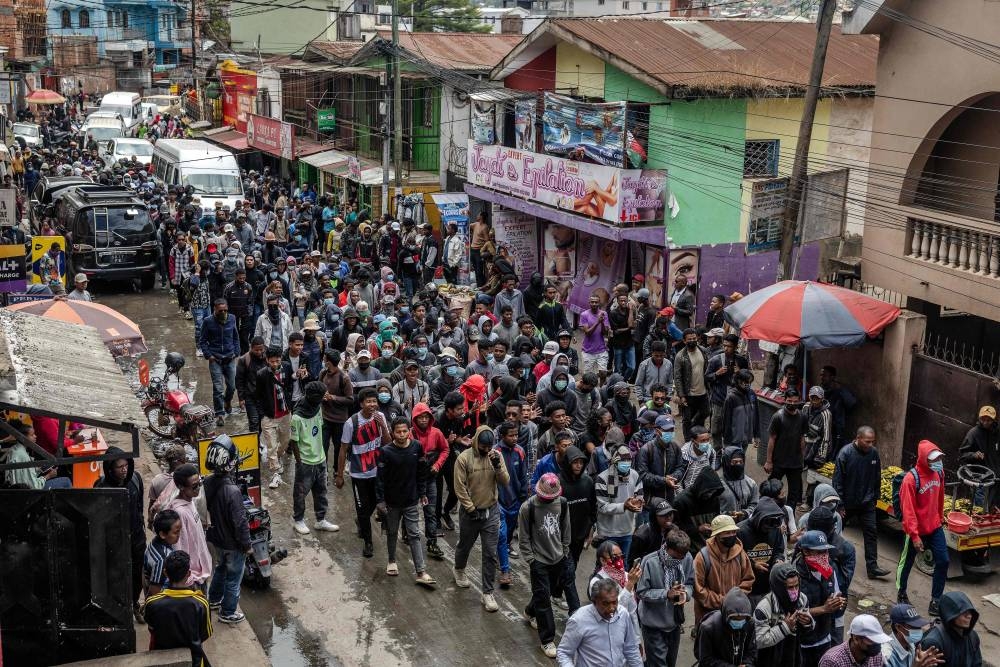 Hundreds of students march along a commercial road on their way to a demonstration calling for the resignation of President Andry Rajoelina, in Antananarivo, on Sunday. AFP
