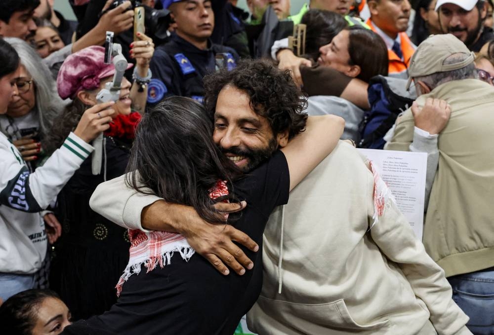 Mexican activist Diego Vazquez is embraced upon arriving at Mexico City International Airport with other Mexican activists who were part of the Global Sumud Flotilla, which sought to deliver aid to Gaza and were detained by Israeli forces, in Mexico City, on Wednesday. REUTERS